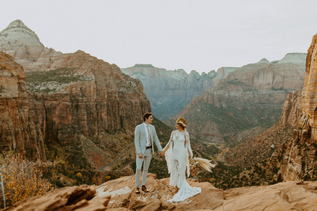 Bride and groom holding hands at Zion national park elopement