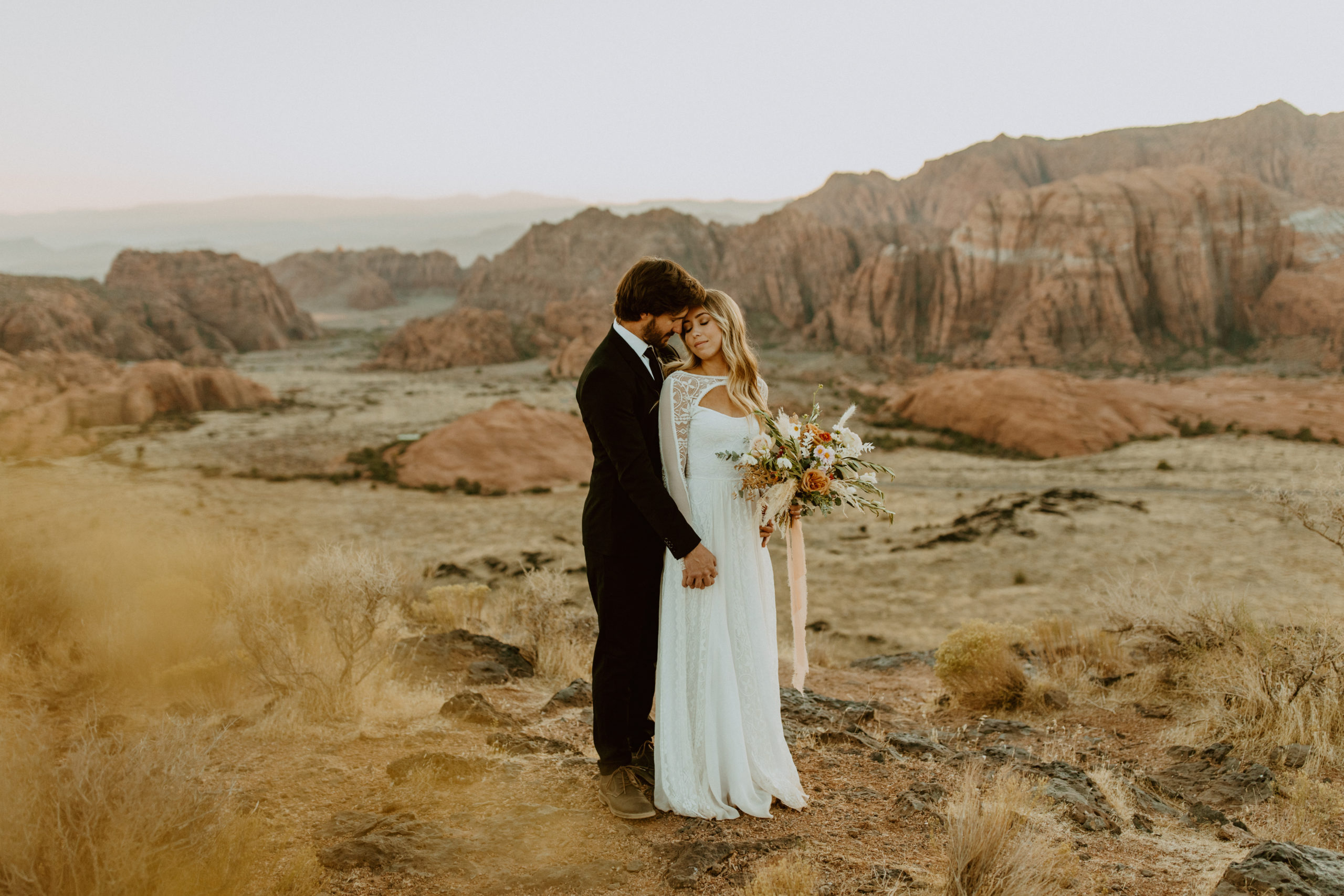 bride and groom holding hands at snow canyon elopement in Utah