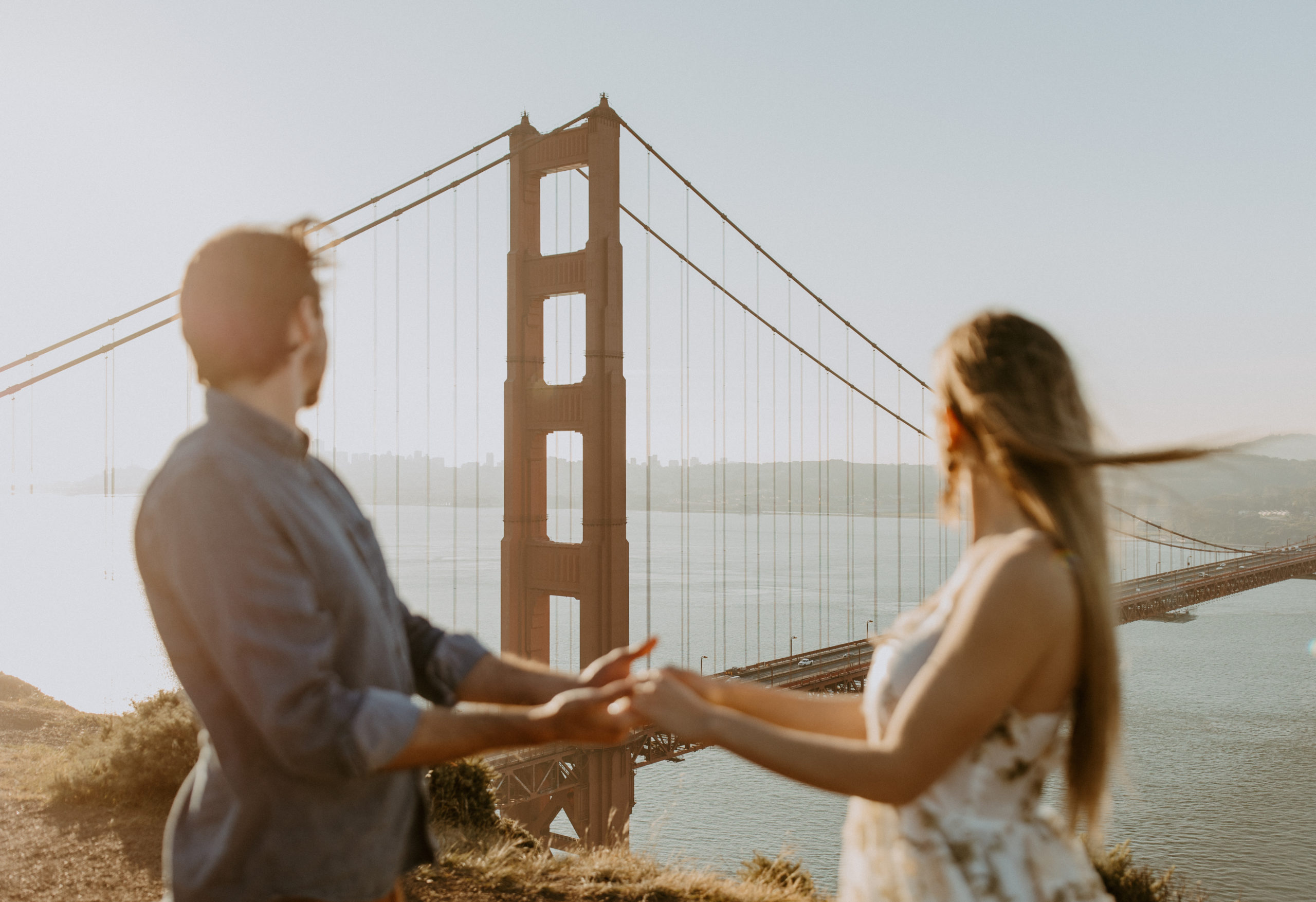 the couple holding hands at the Golden Gate Bridge in San Francisco