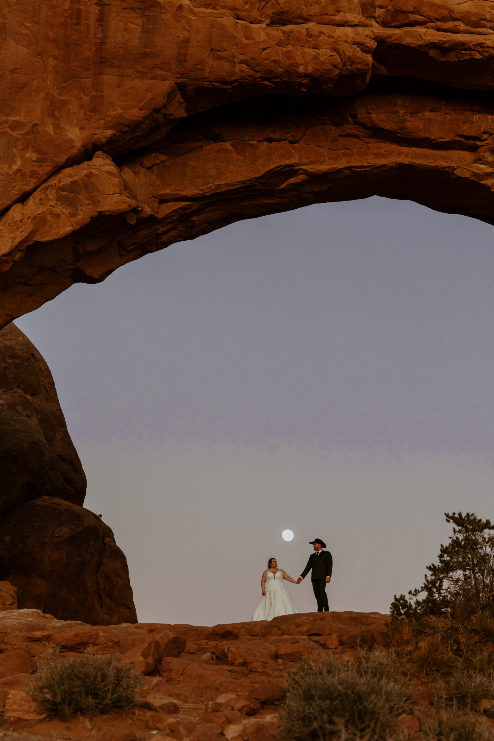 the couple walking together along the arches