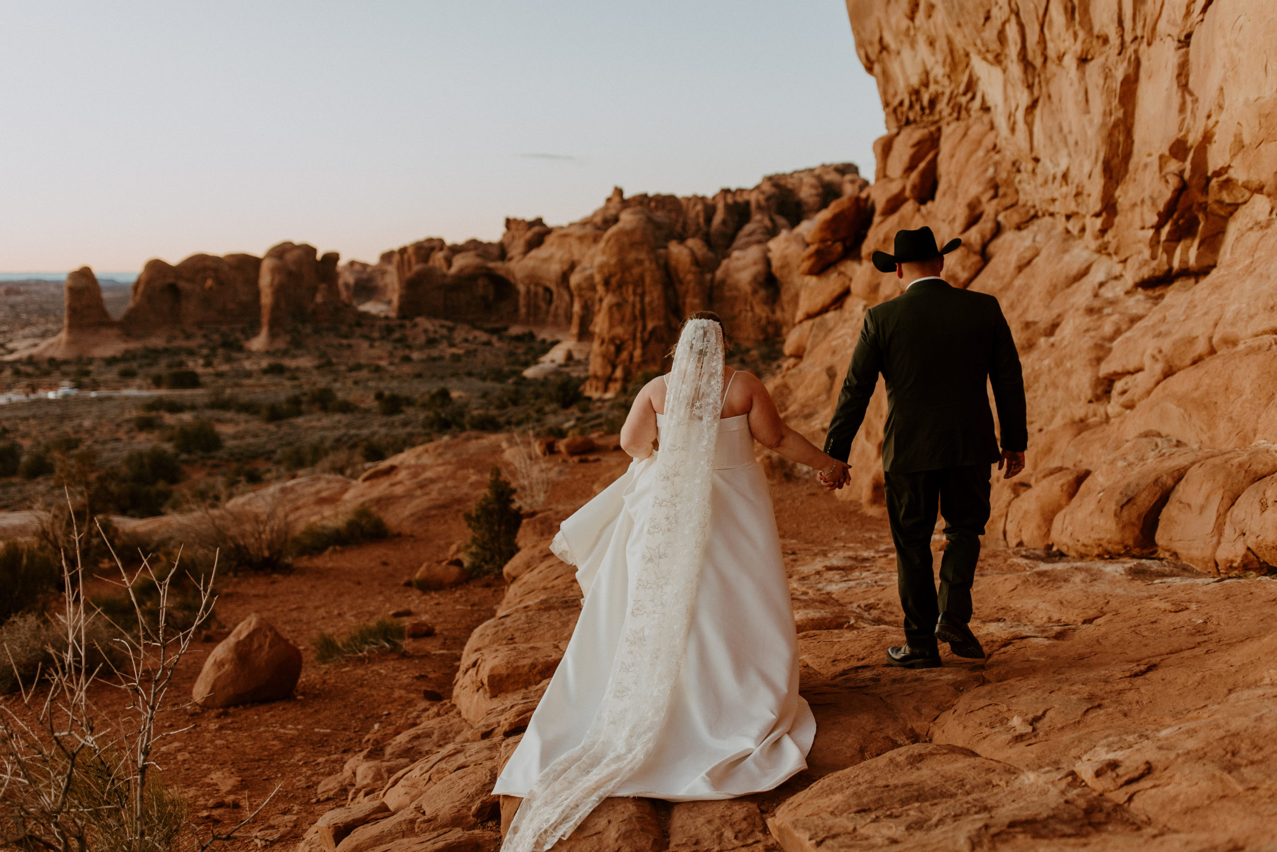 couple walking at Arches National Park in Utah away from the photographer