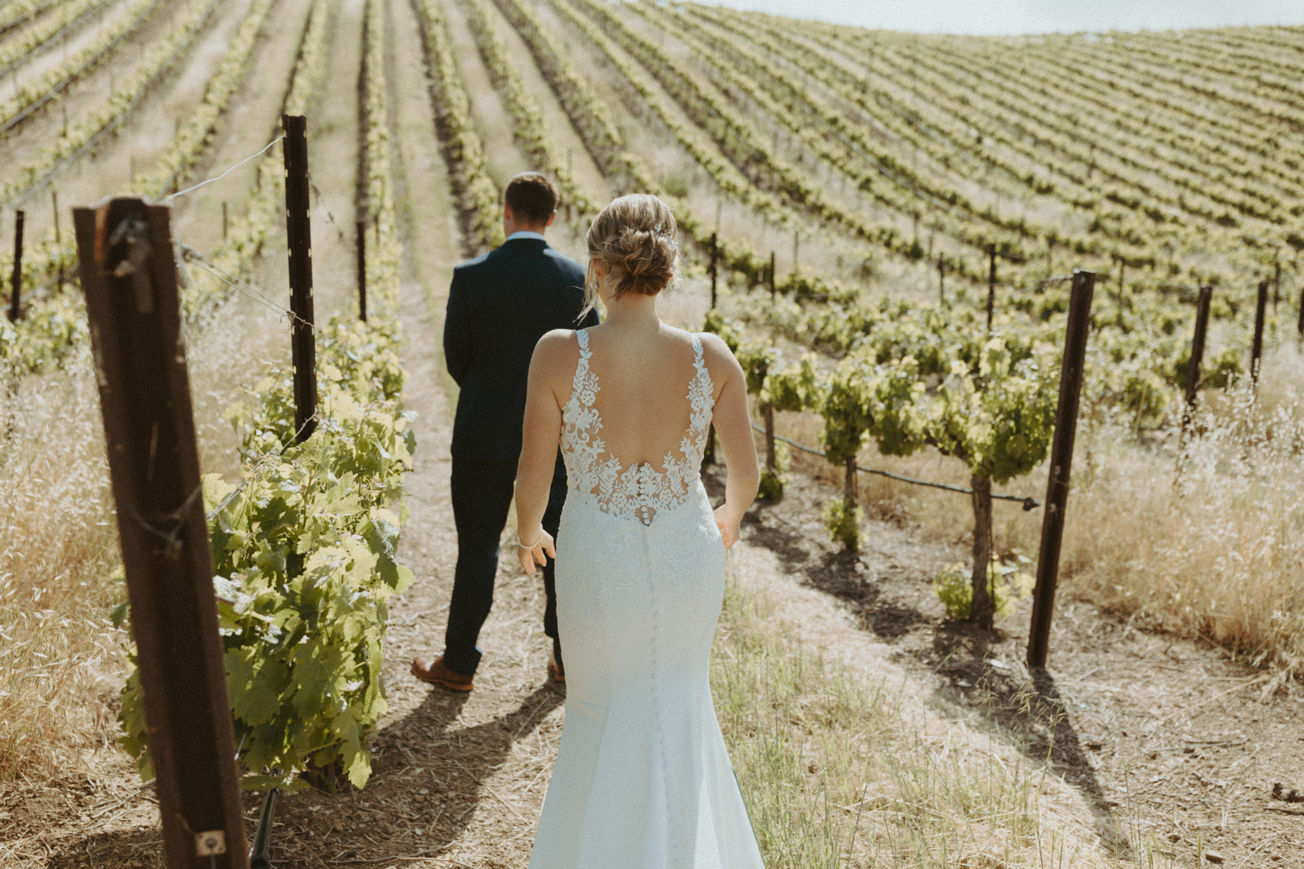 bride walking towards her groom at the vineyard in California