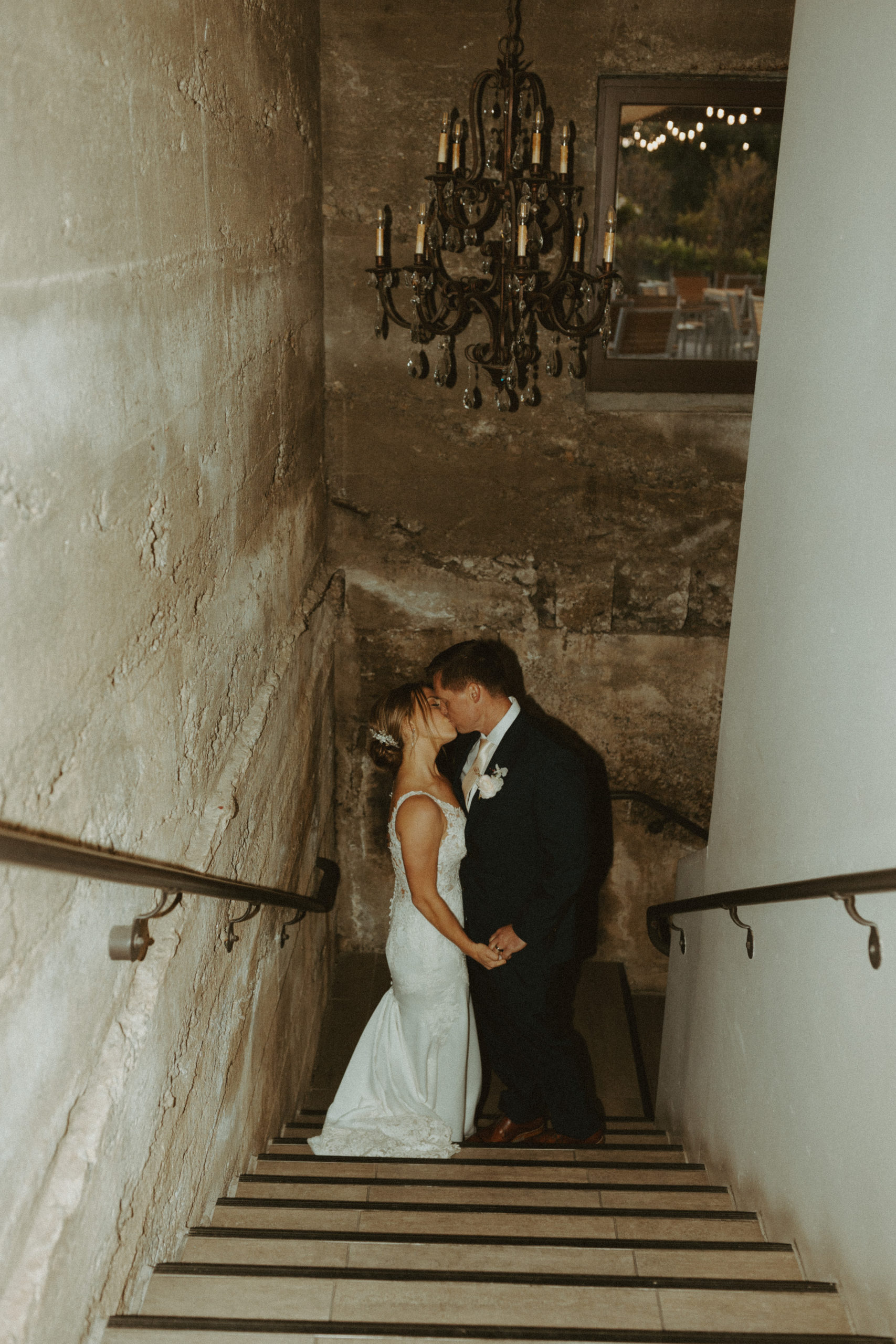 the couple kissing in the stairway of the vineyard in California