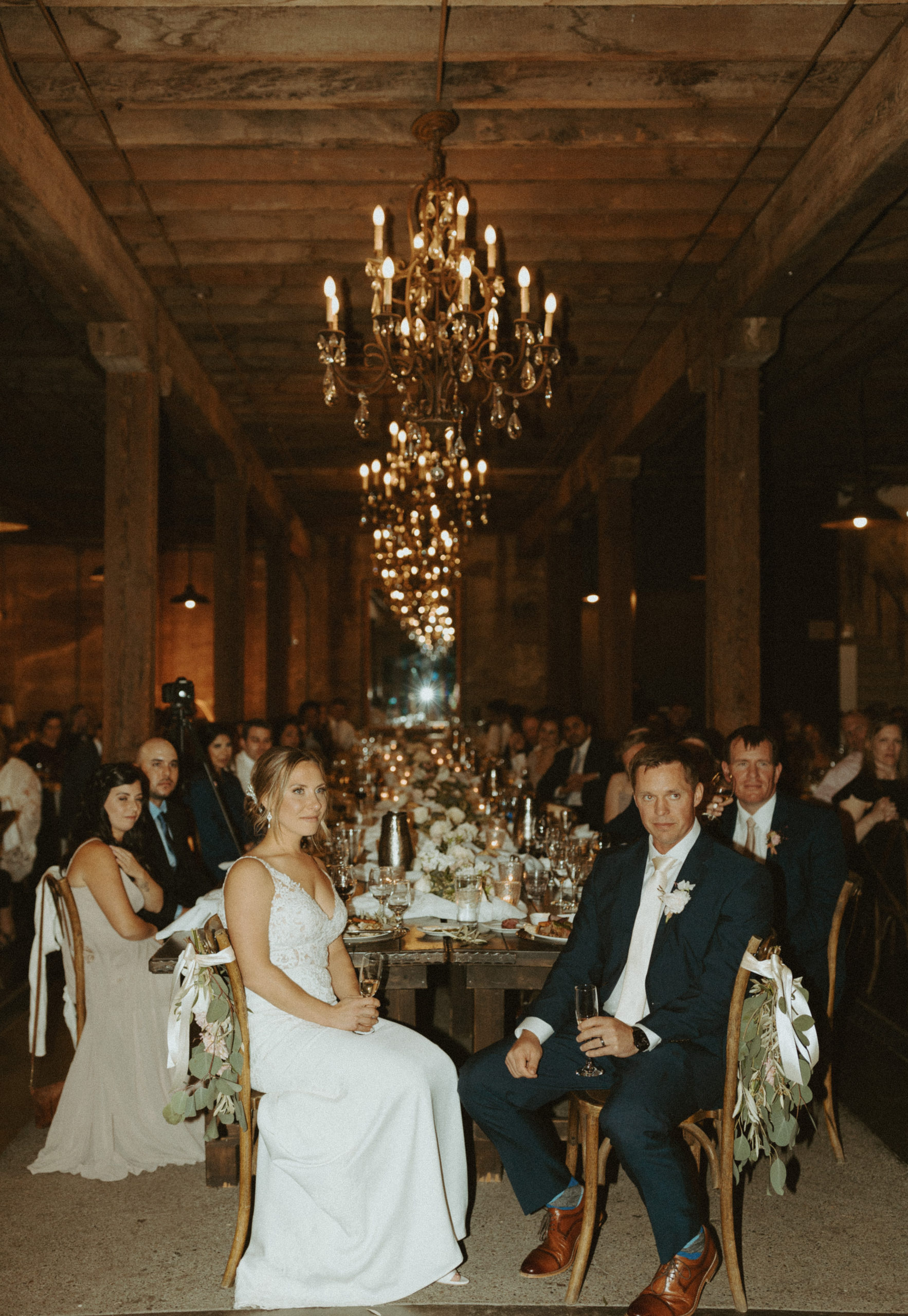 the couple sitting at their reception in the Barrel Room