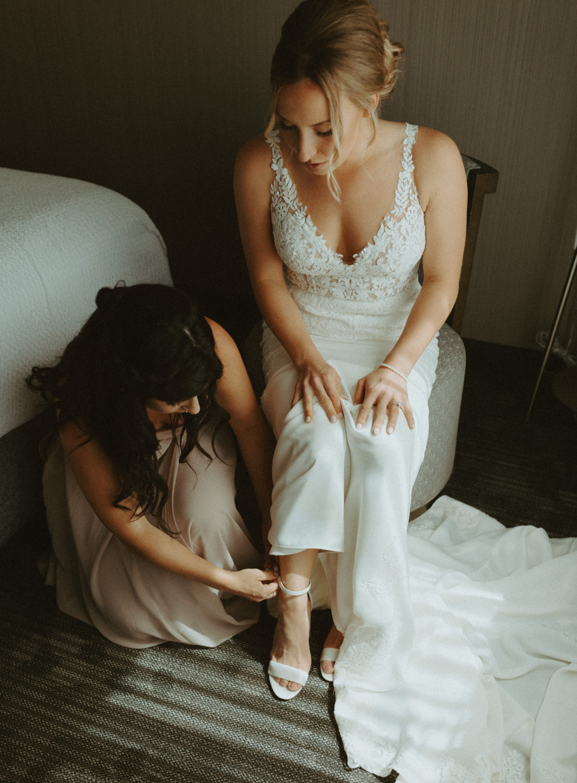 the bridesmaid putting on the bride's shoes
