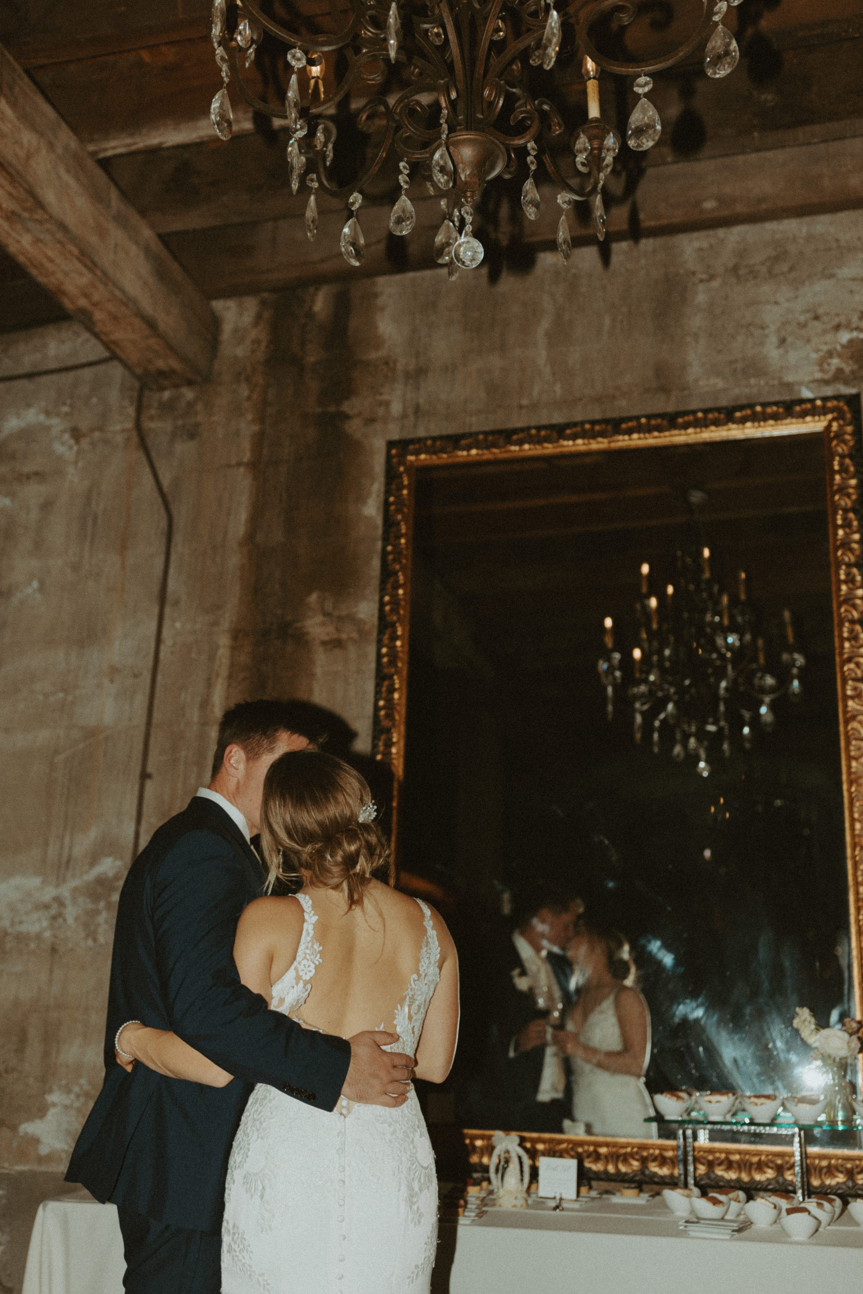 the couple kissing by the mirror during the reception at the venue in California