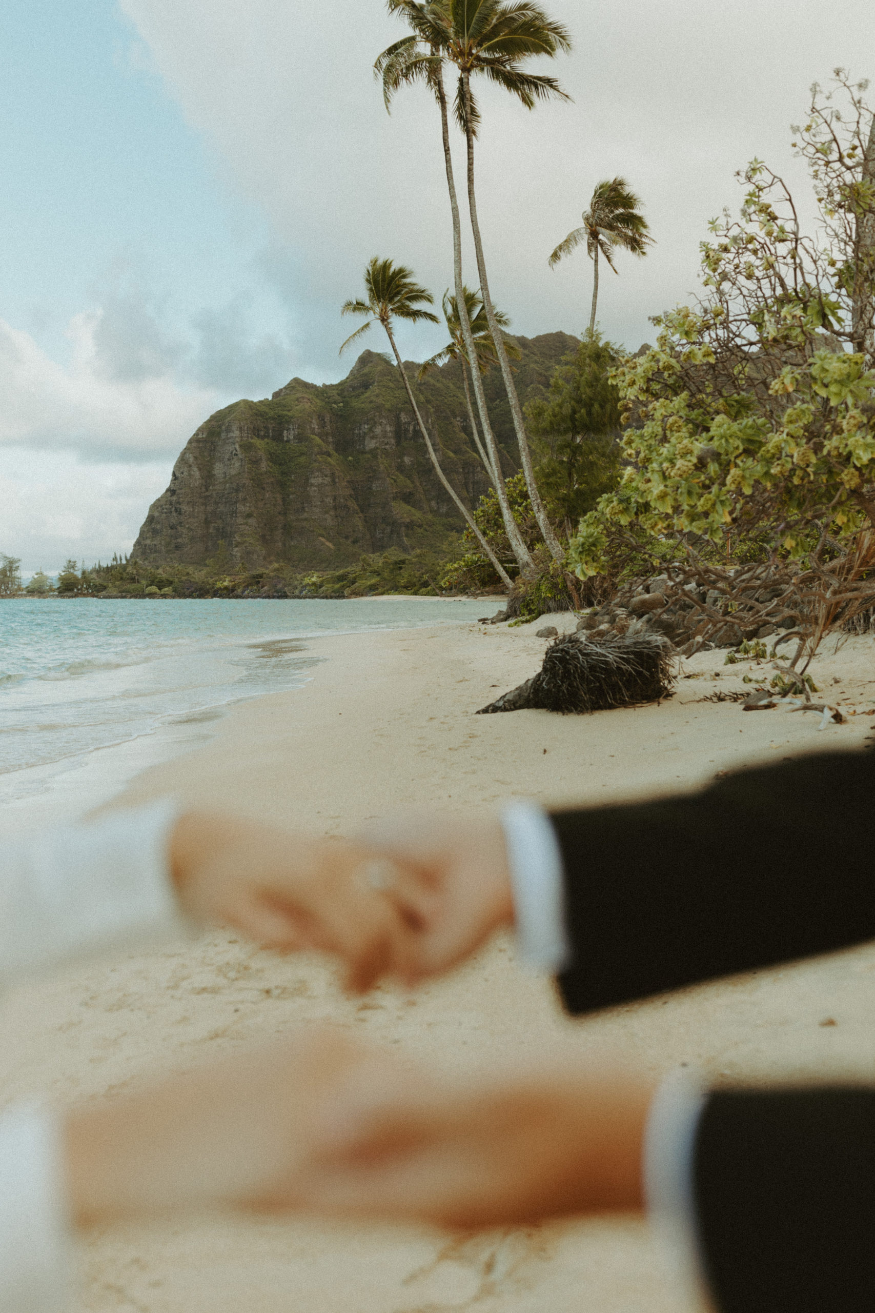 the couple holding hands on the Hawaii beach