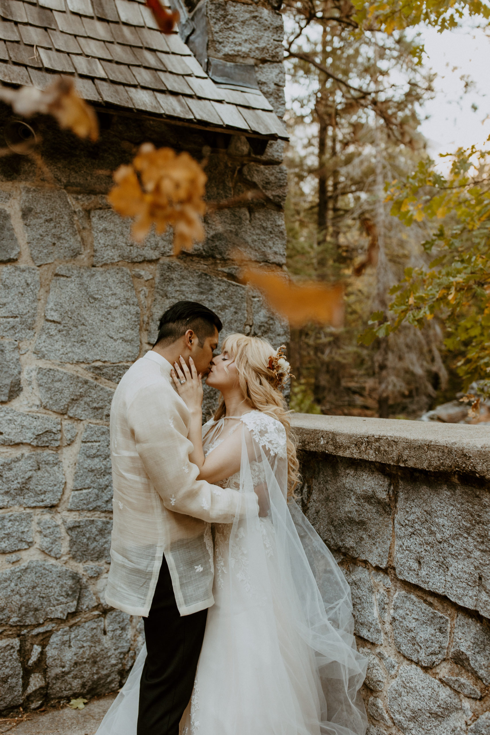 the couple kissing as fall leaves fall