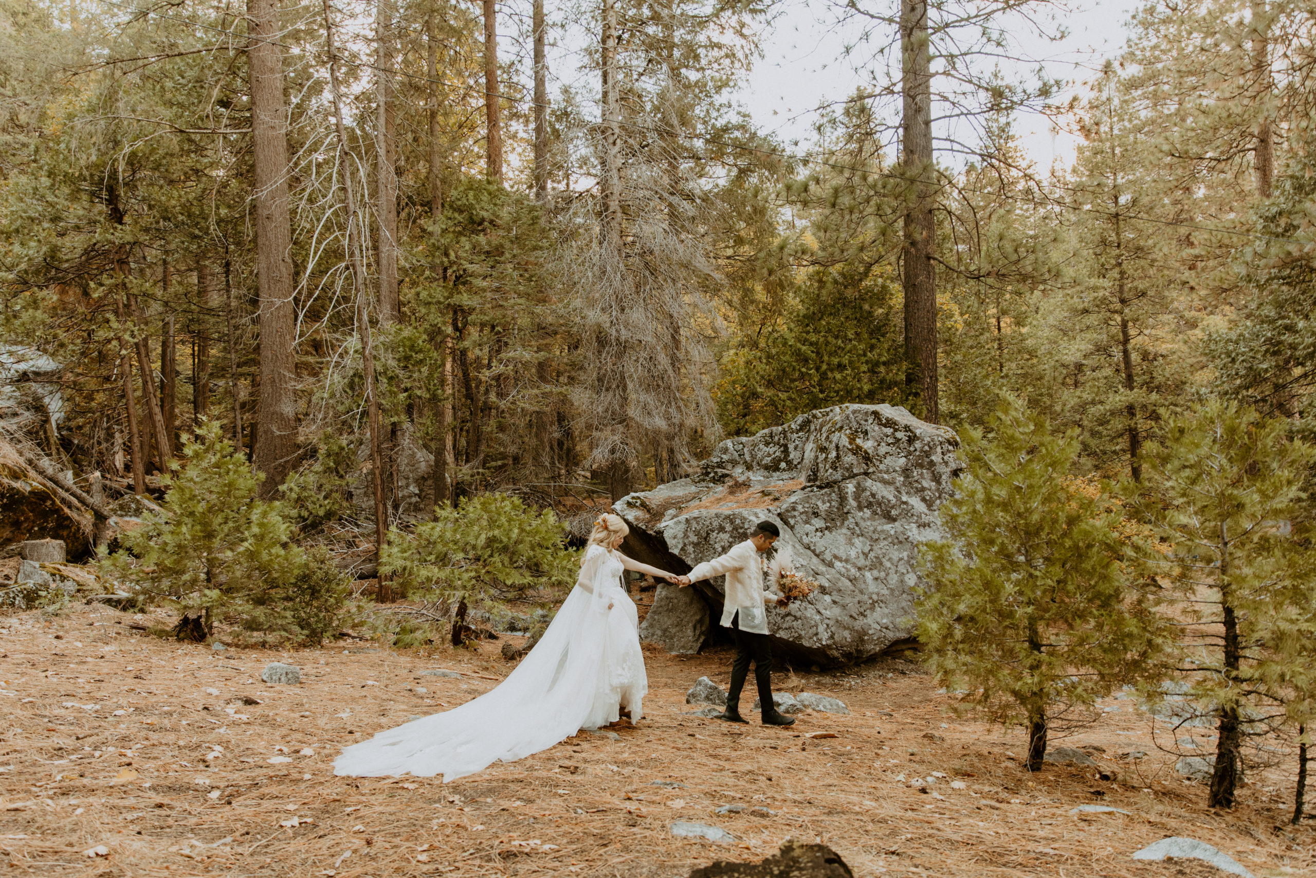 the couple walking through the forest during their elopement in Yosemite