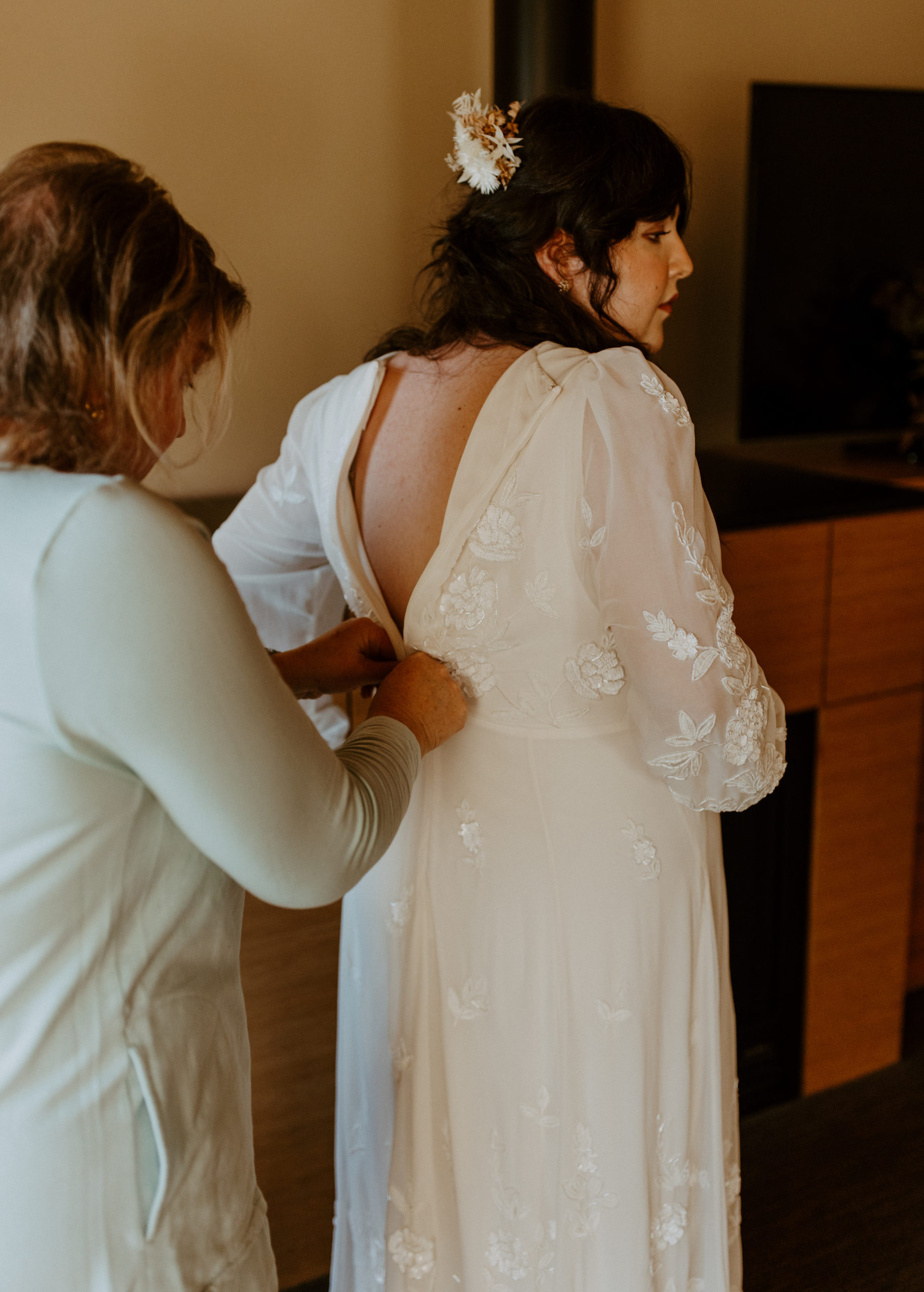 the bride getting her wedding dress on 