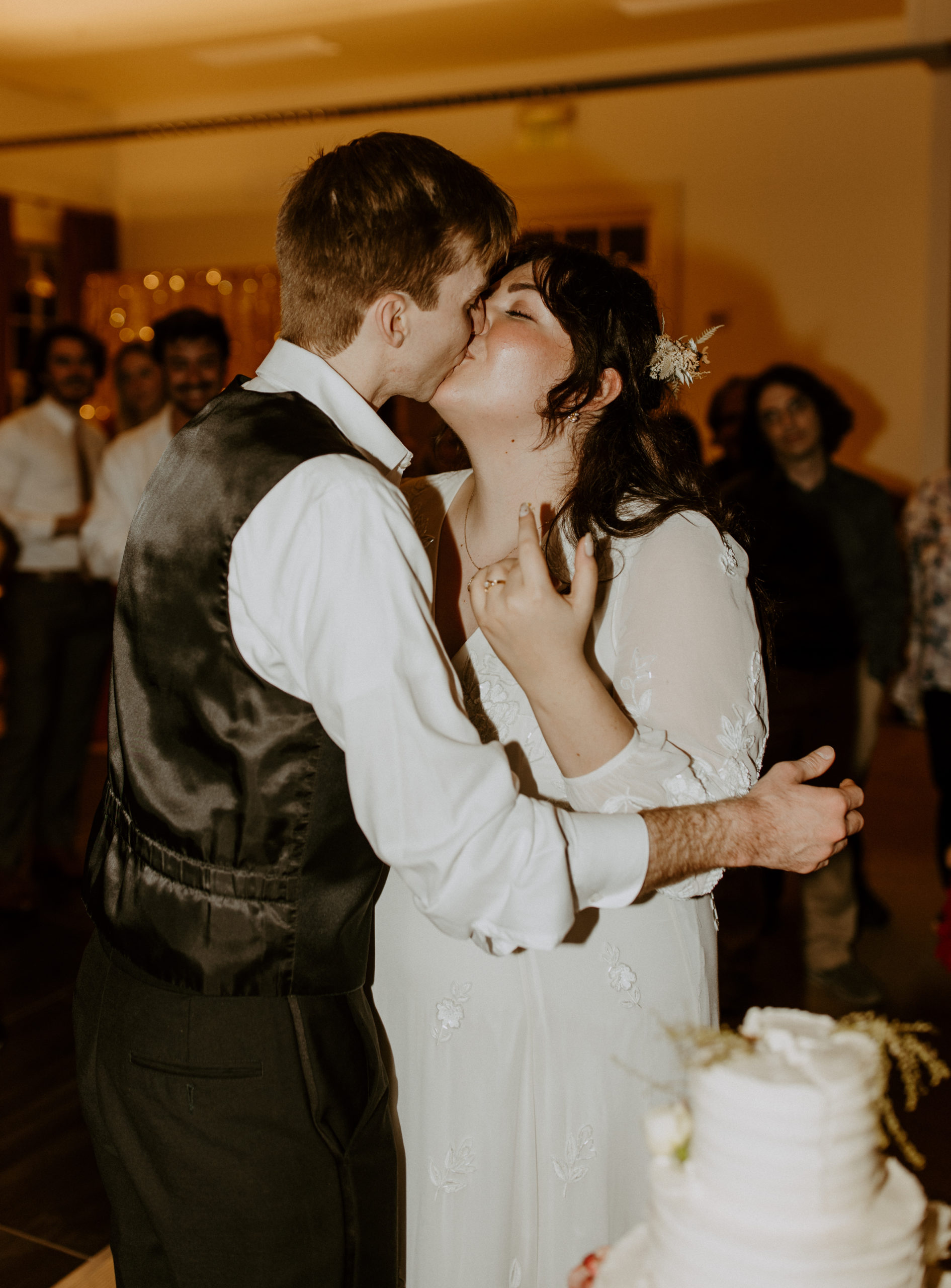 the couple kissing after cutting the cake