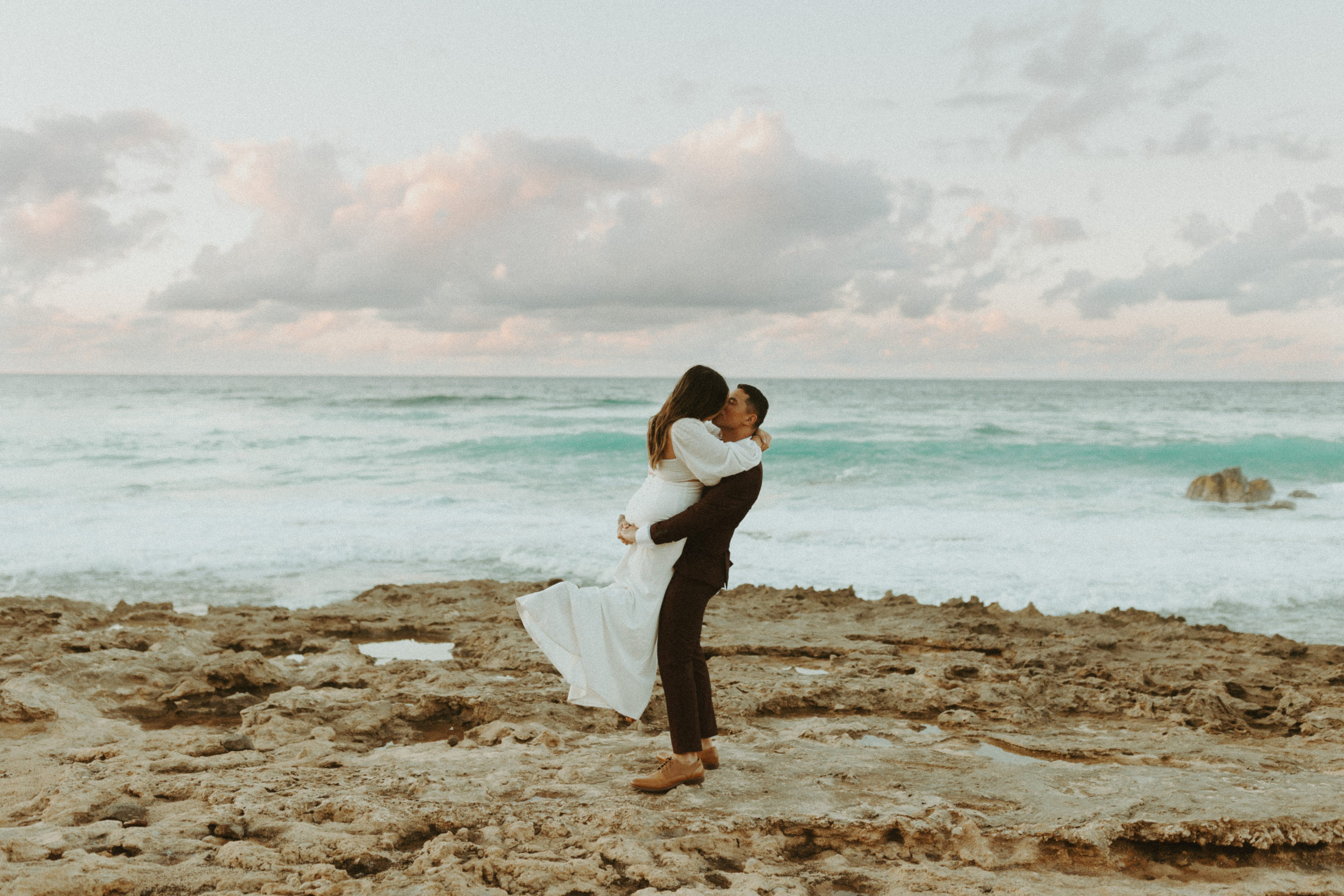 the couple kissing at the beach for their Oahu sunset bridal session