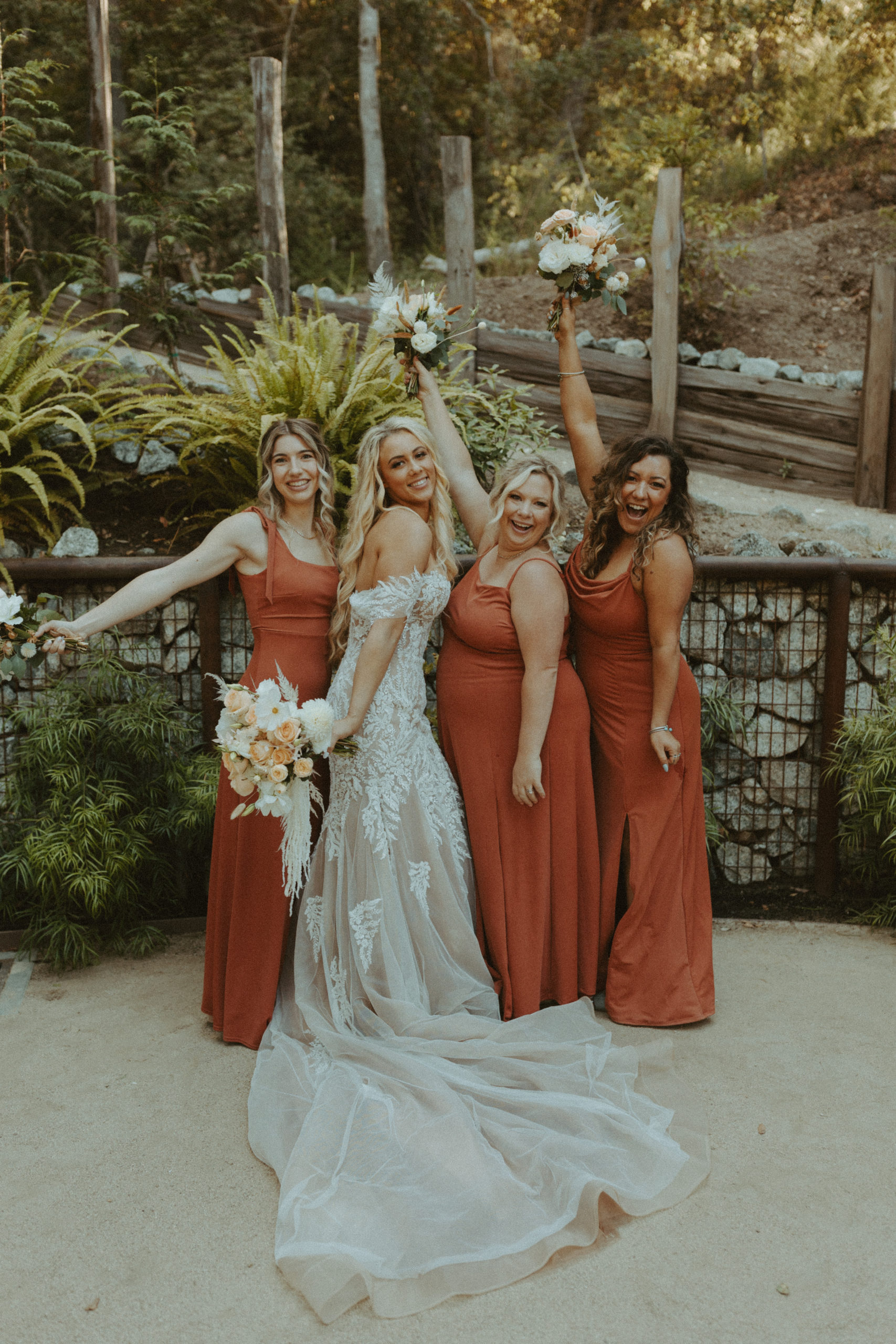 the bridesmaids lifting their bouquet with the bride