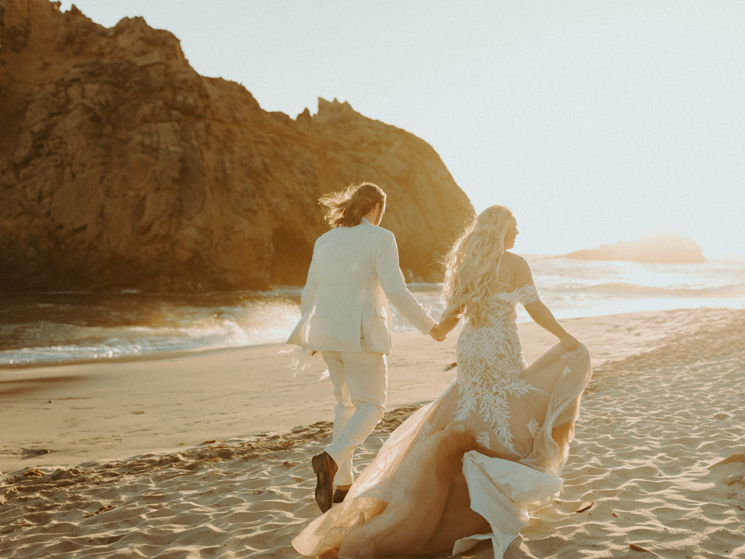 the couple walking away towards the sun at their Big Sur Wedding