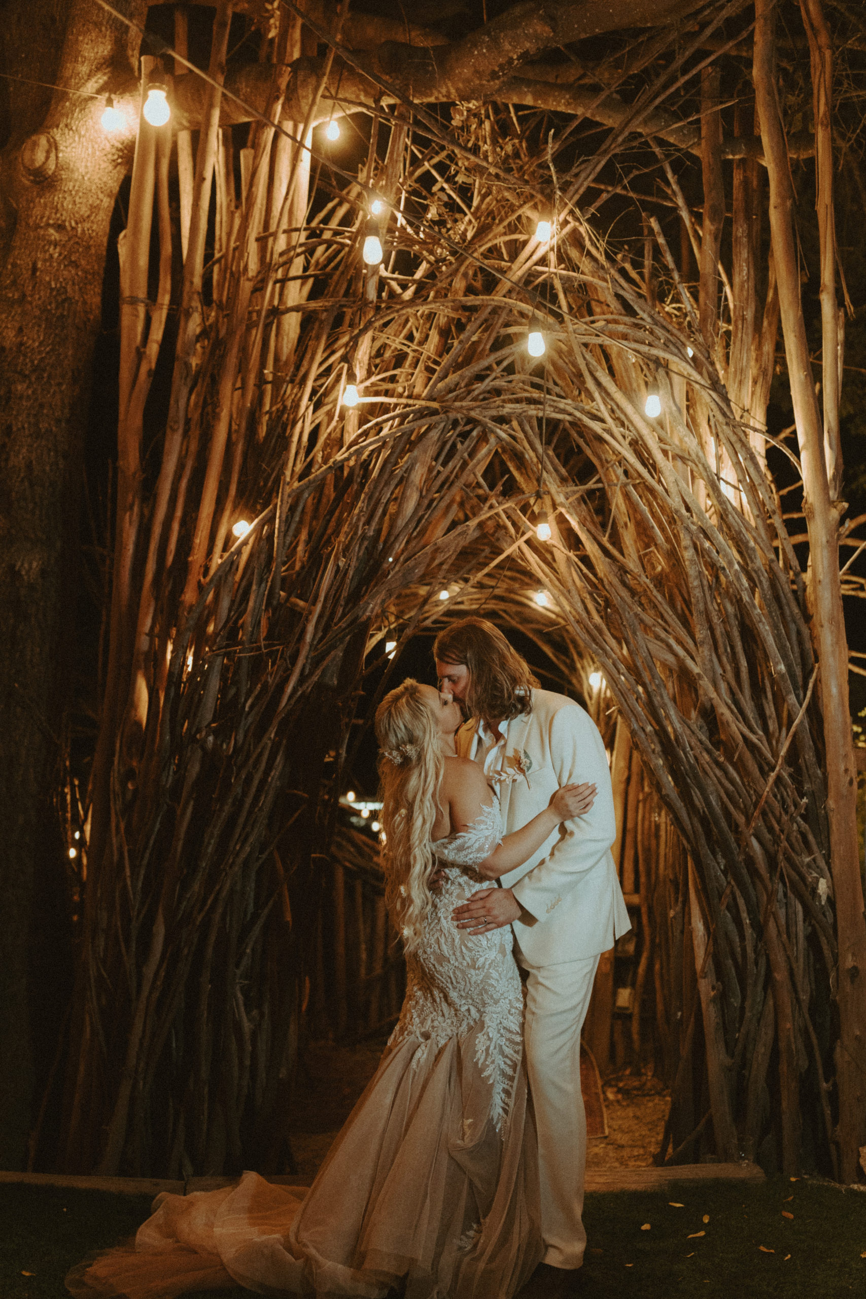 the couple kissing underneath the fairy lights