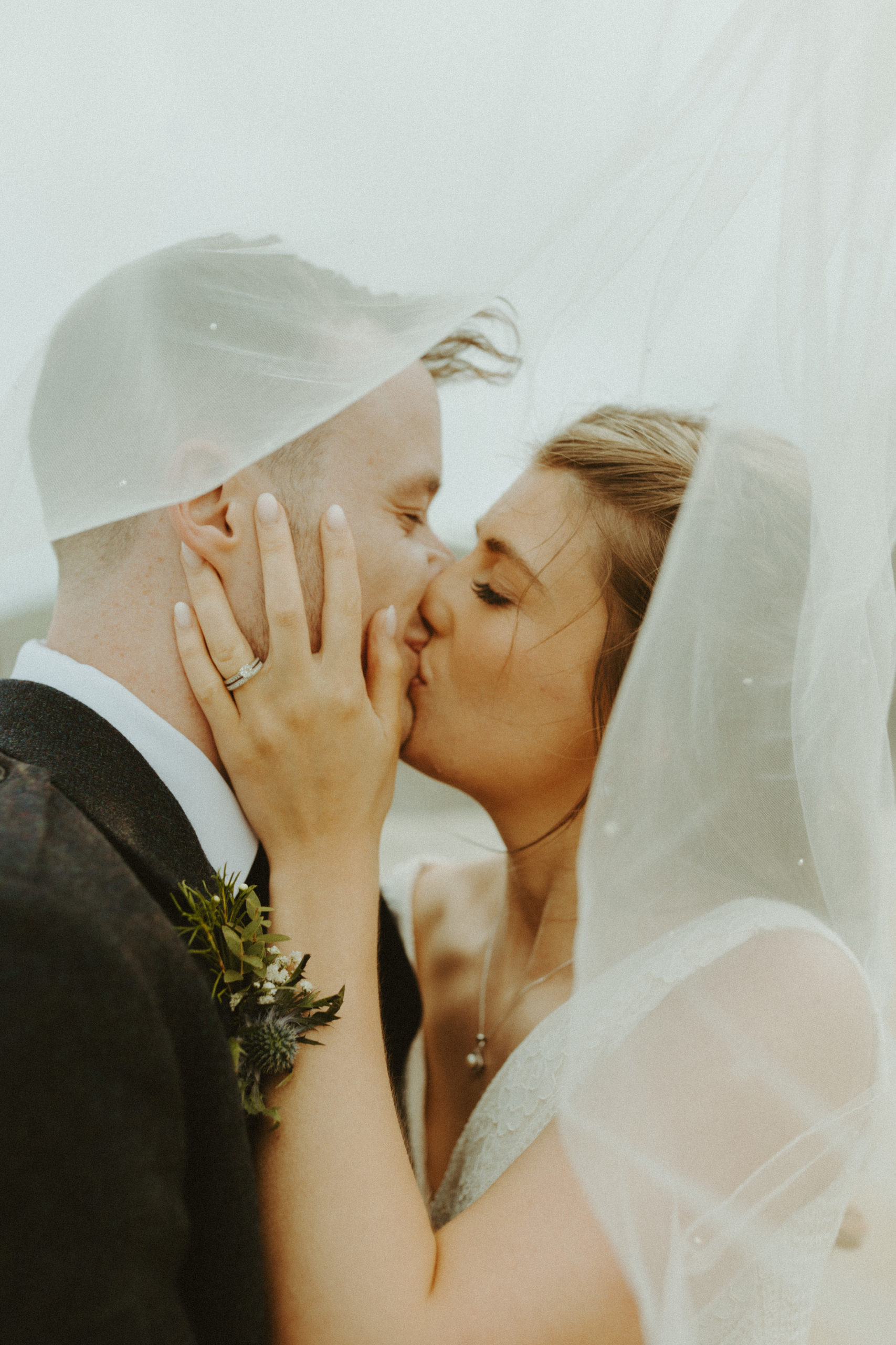 the couple kissing under the veil