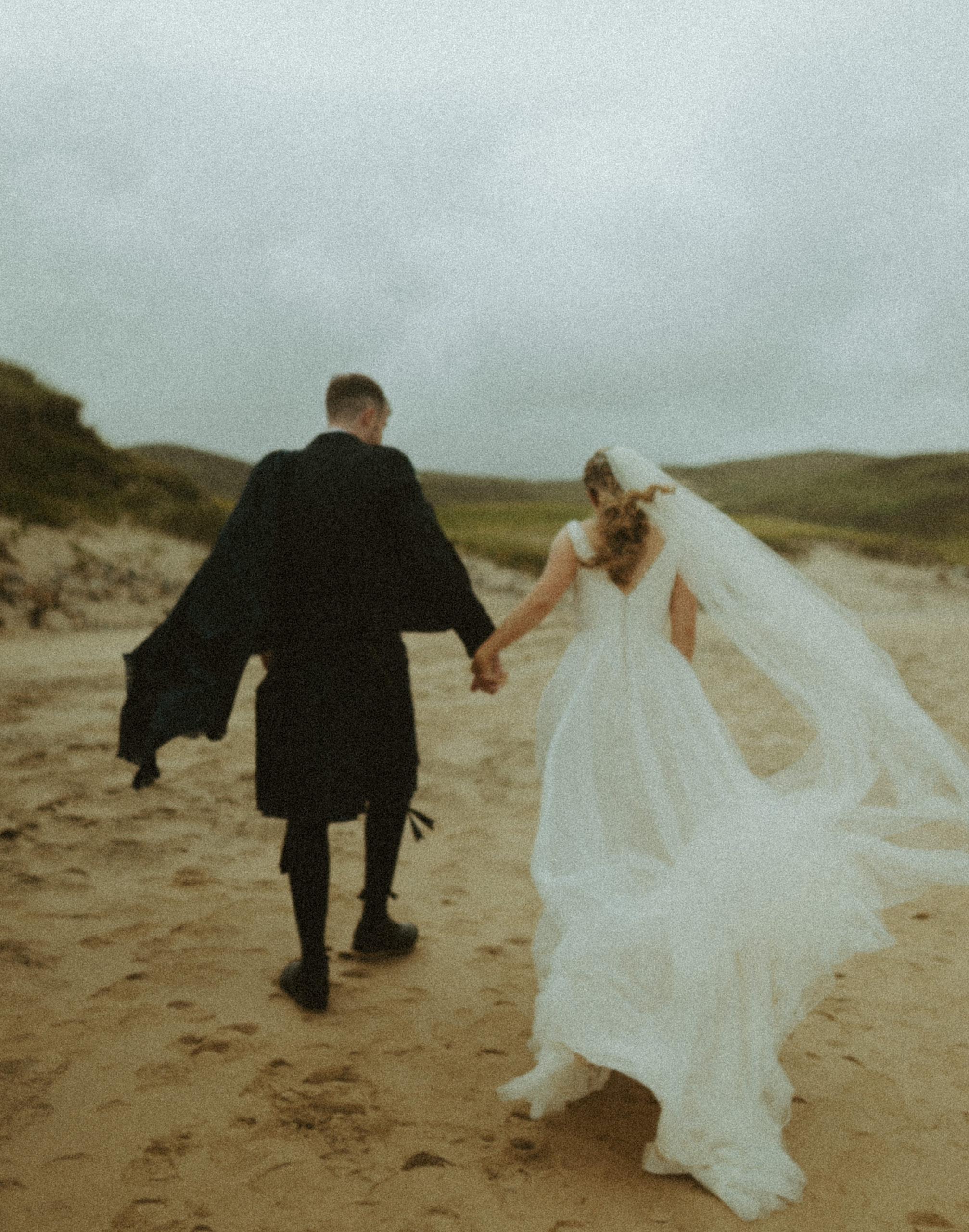 the couple running through the sand