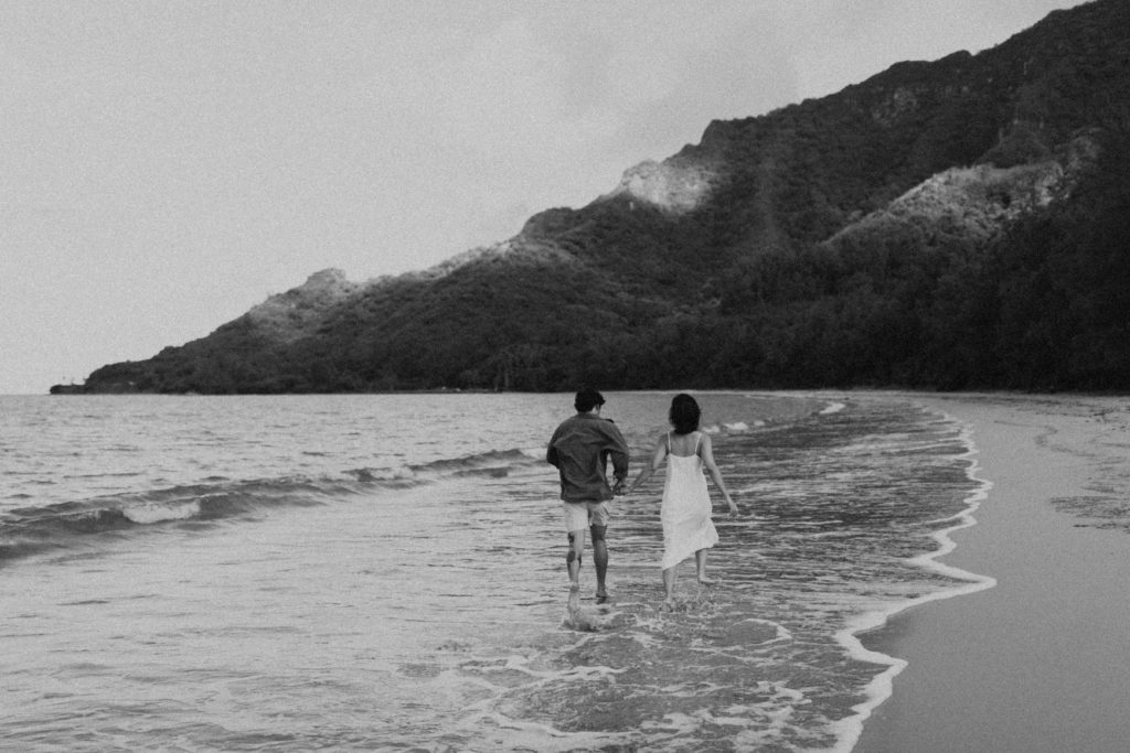 the couple walking away from the Hawaii couples photographer in the water