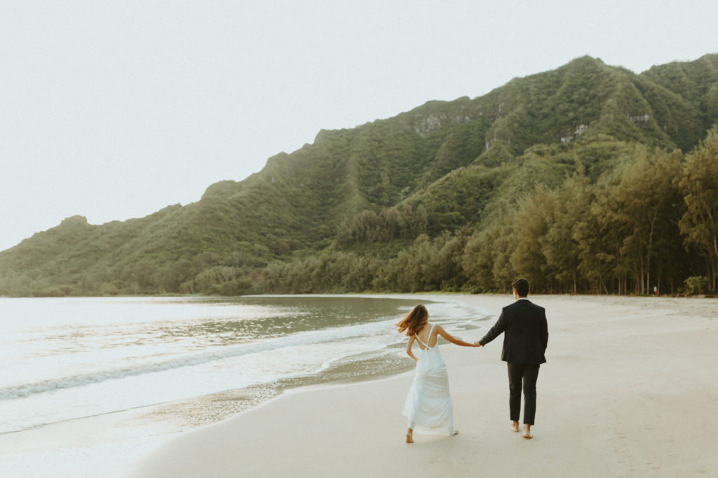 the couple walking down the beach away from the Hawaii photographer
