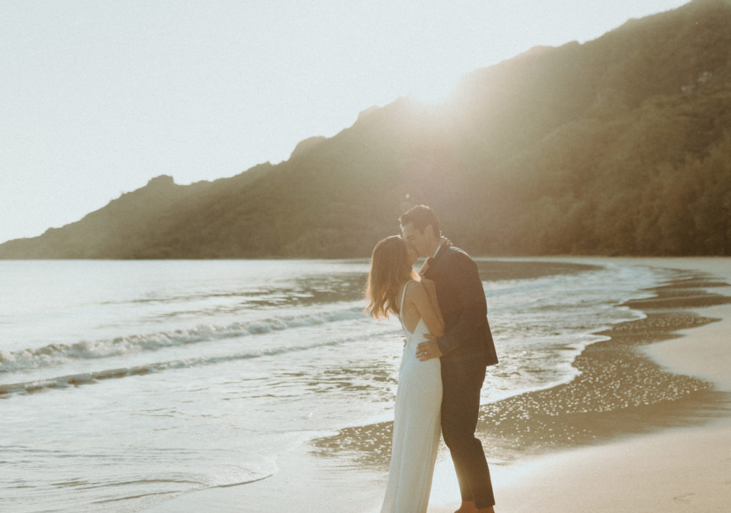 the couple kissing on the beach during their Hawaii photoshoot
