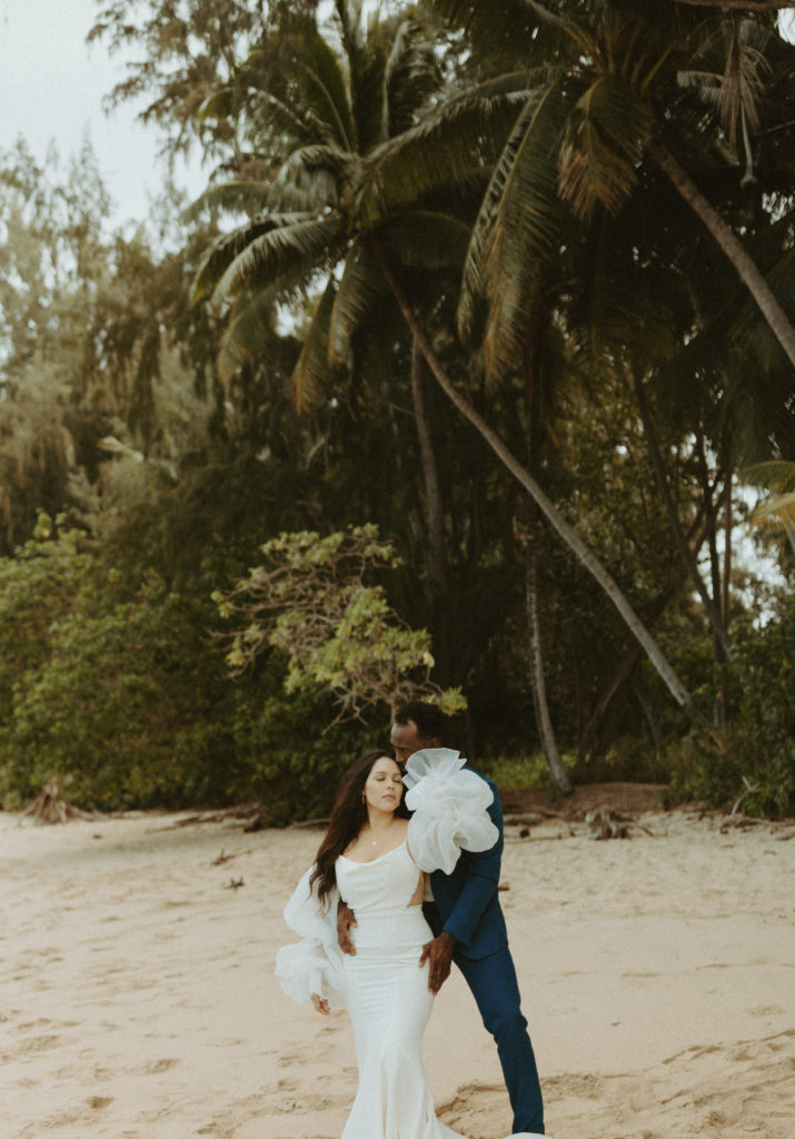 the wedding couple posing on the beach in Hawaii together