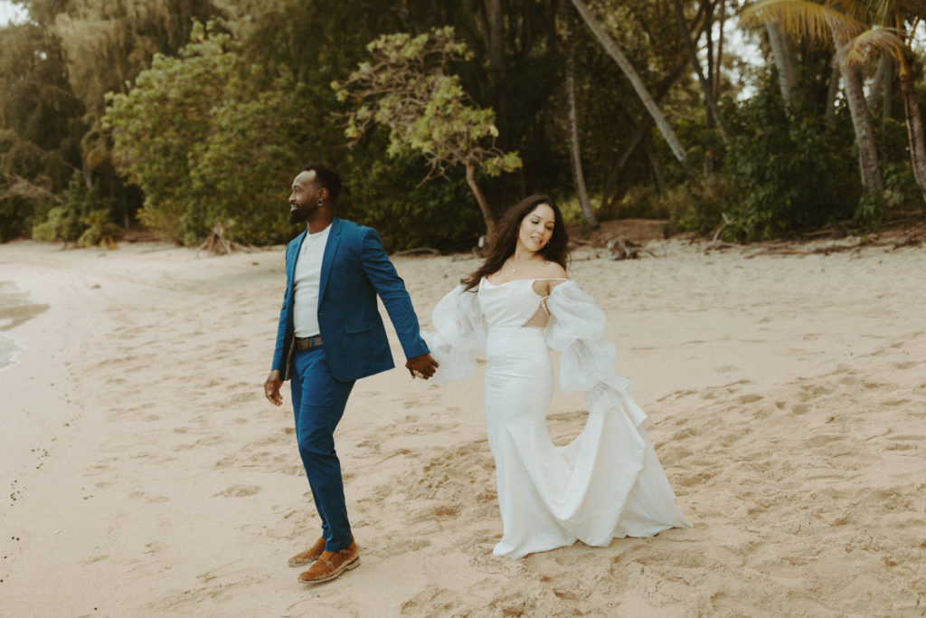 the couple walking towards the ocean during their Hawaii wedding photos