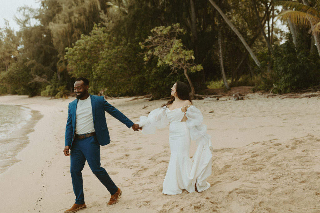 the couple walking down the beach in their wedding attire during their Hawaii elopement