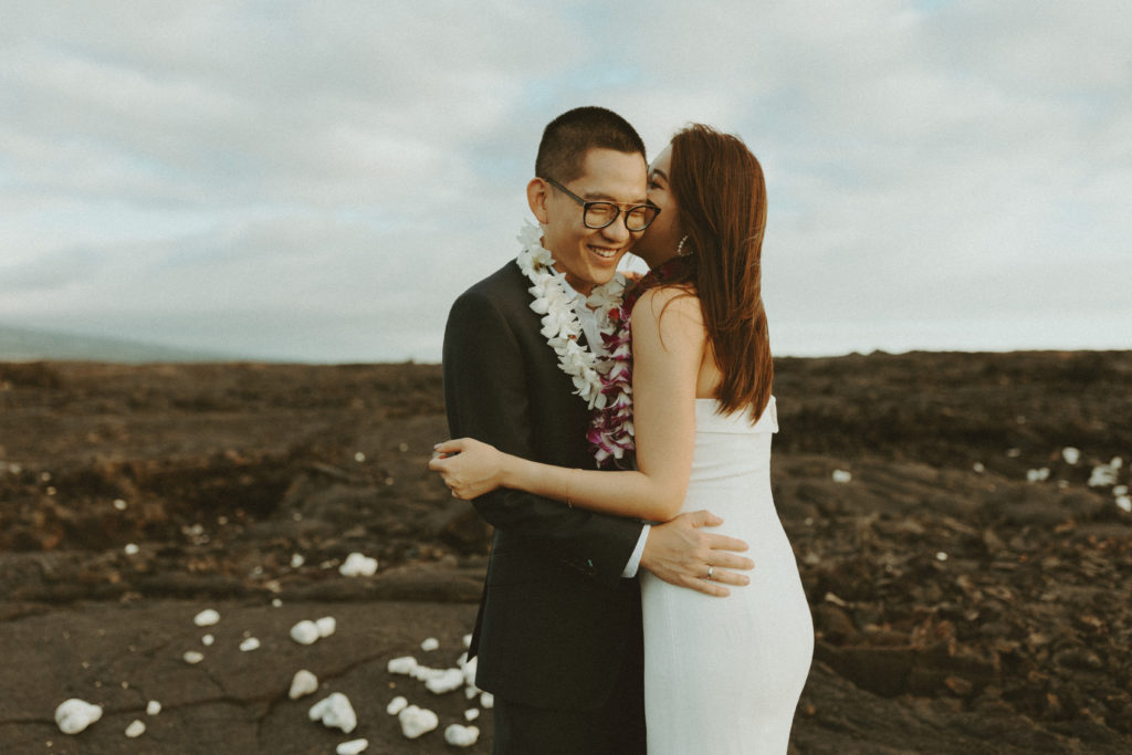 the couple laughing together on the lava rock in Hawaii