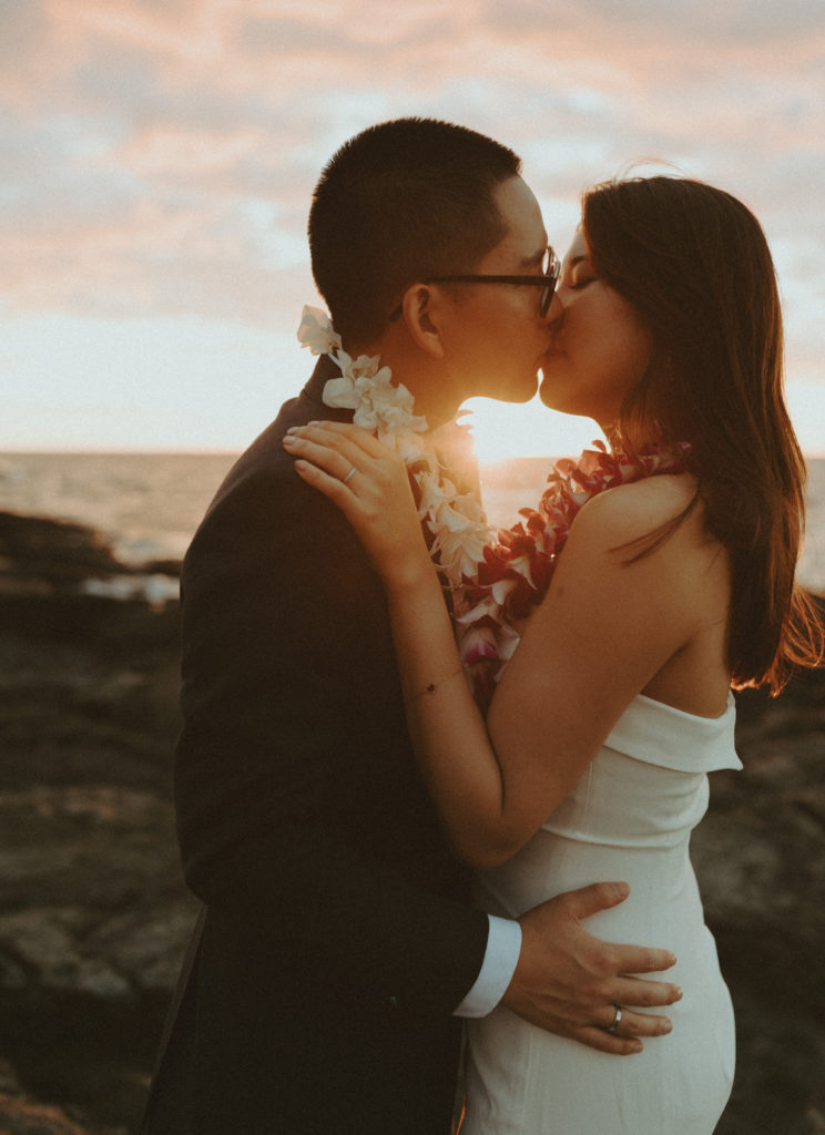 the wedding couple kissing during sunset in Hawaii 