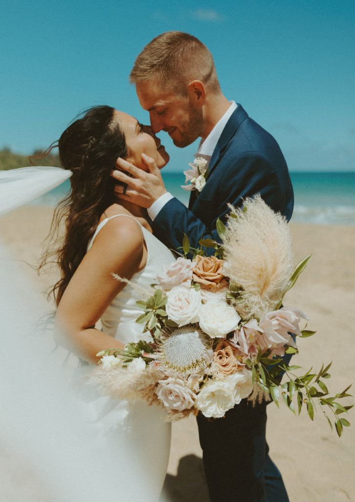 the couple leaning in for a kiss during their Kauai elopement on the beach