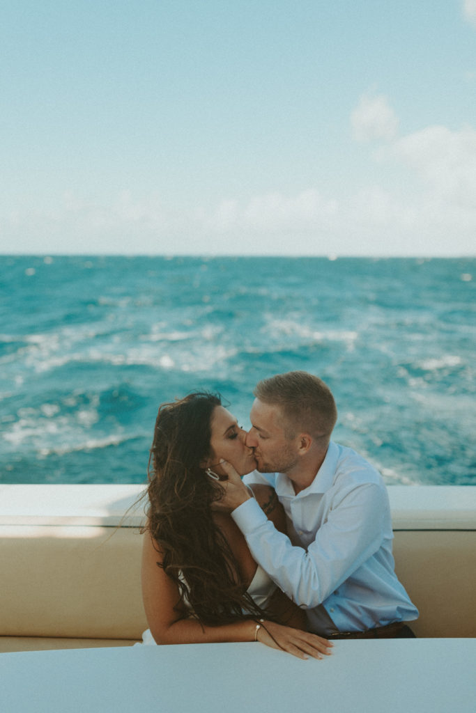 the couple kissing as the sit on the back of the boat during their Kauai elopement