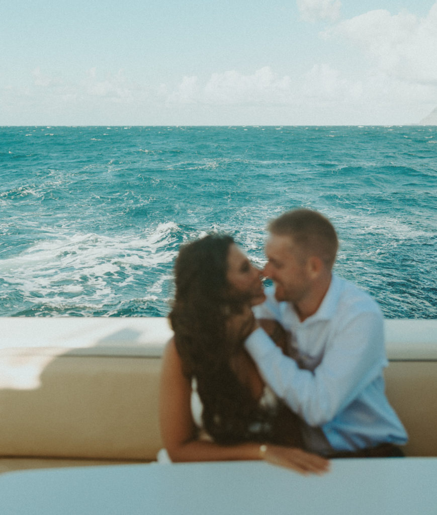 the couple leaning in for a kiss during their boat ride in Hawaii 