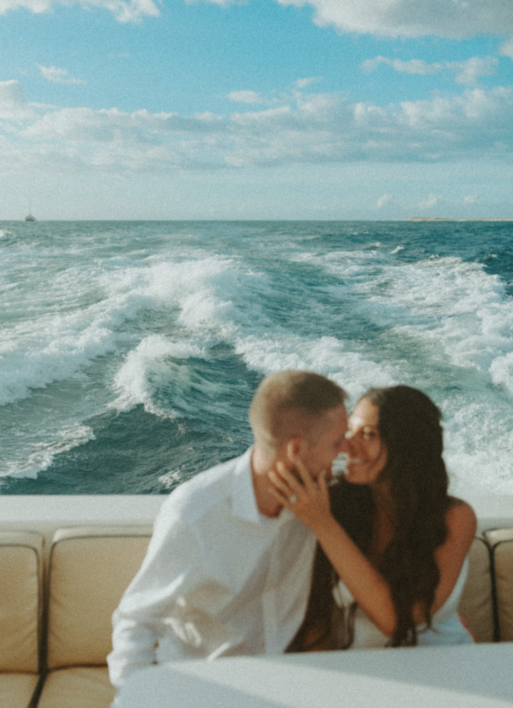 the couple laughing at one another as they ride on a boat after their elopement ceremony in Kauai