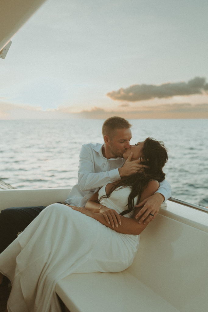 the elopement couple kissing during sunset on a boat in Hawaii 