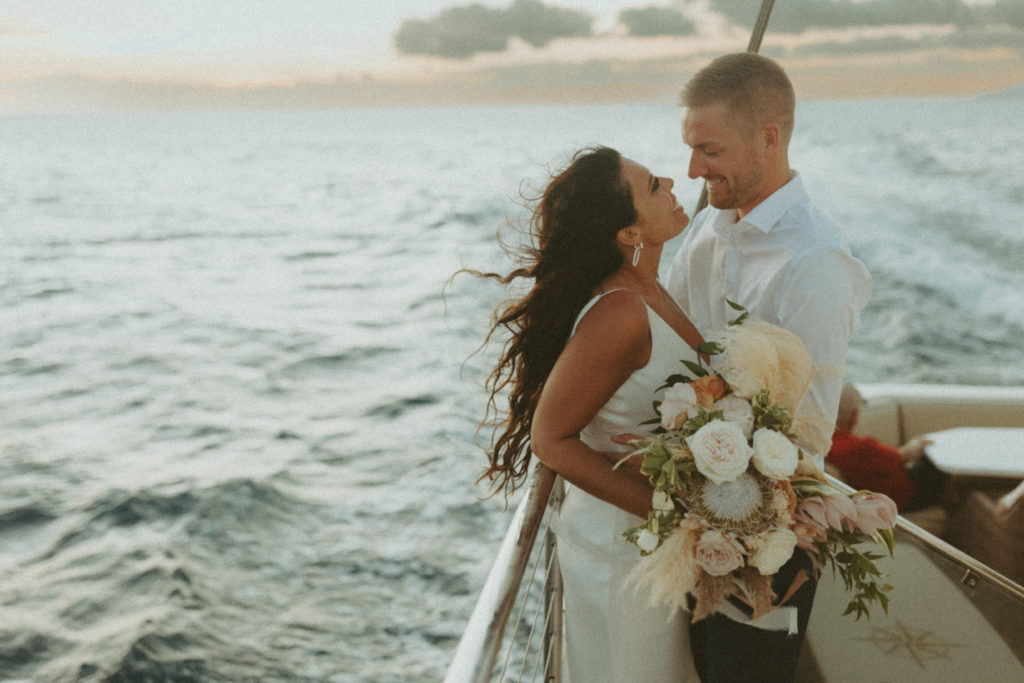 the couple looking smiling at one another during their elopement on the boat