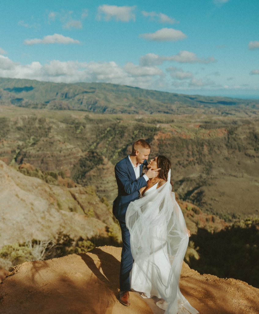 the couple leaning in for a kiss at the canyon in Kauai