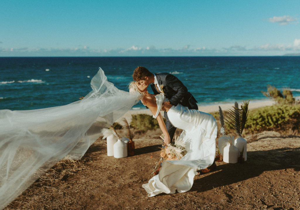 The bride and groom kissing in Oahu during their elopement