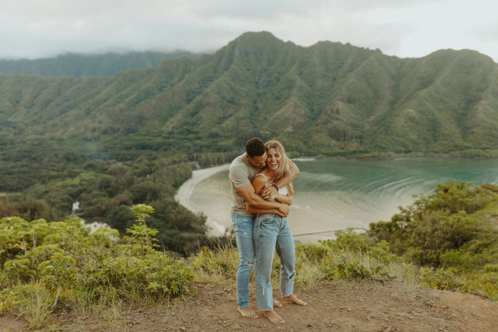 the couple wrapping their arms around each other as a couples photography pose in Hawaii