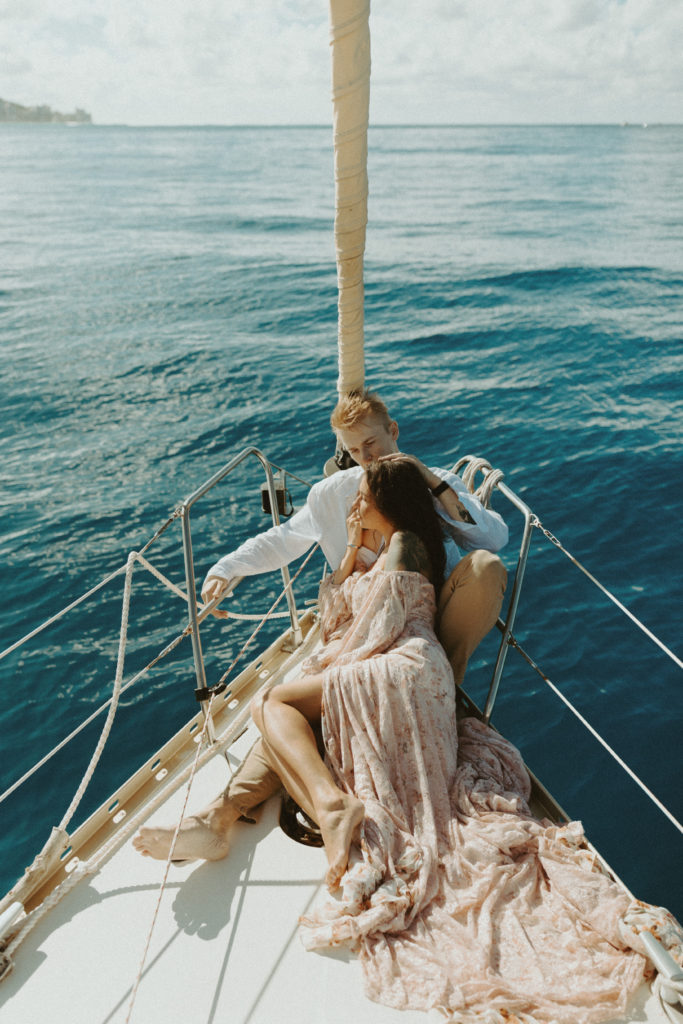 the couple sitting down together on the sailboat