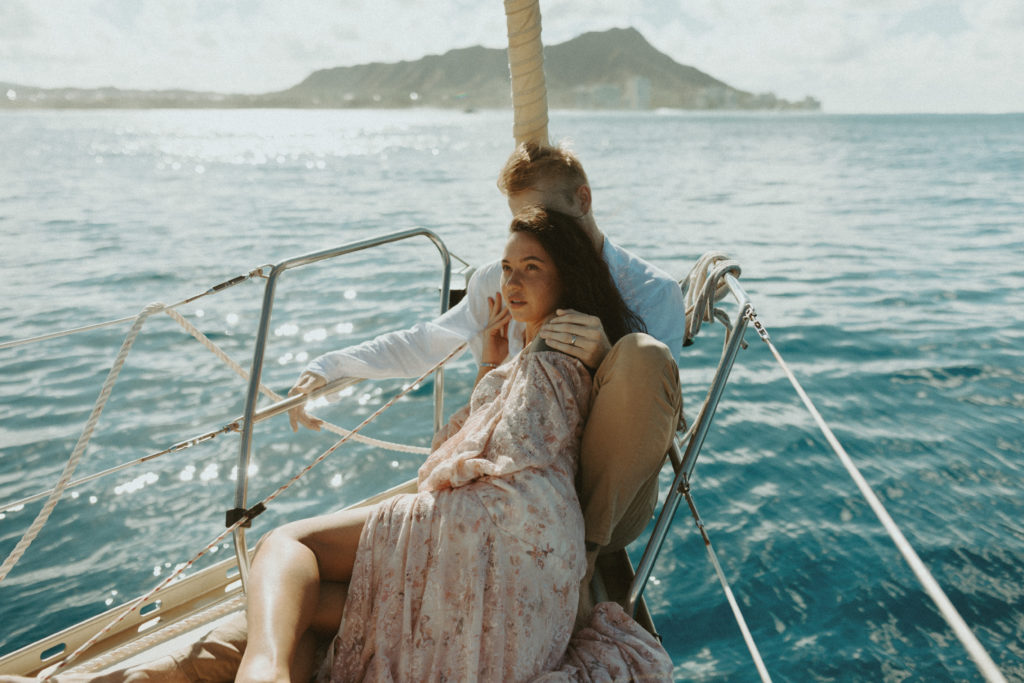 the couple laying together during their couple photoshoot on the sailboat