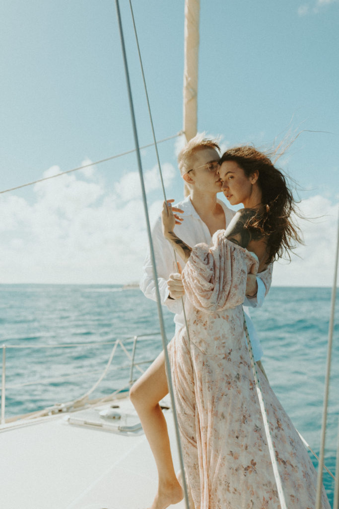 the couple posing together on the sailboat in Hawaii