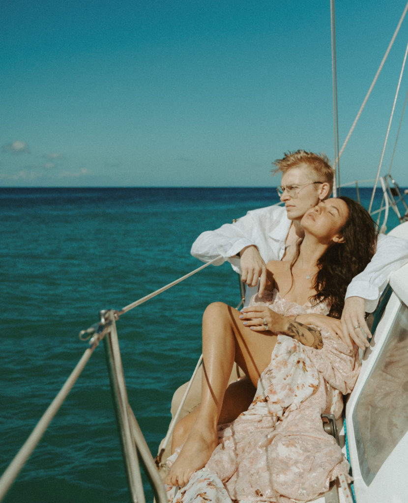 the couple sitting together on the sailboat in Hawaii
