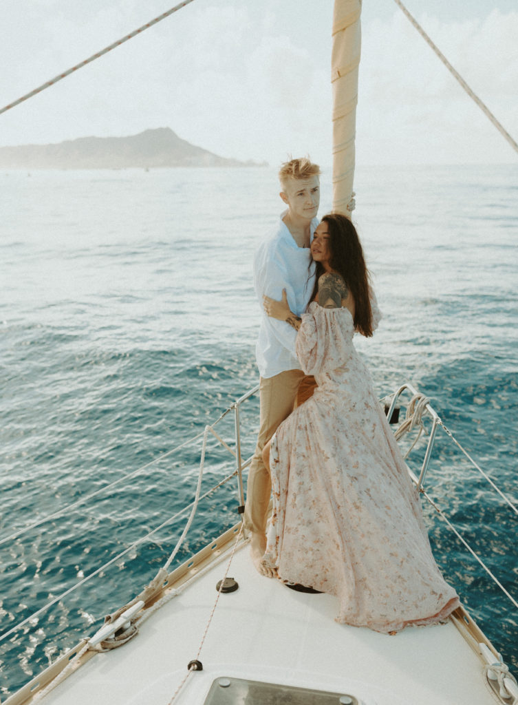 the couple standing together on the sailboat in Oahu