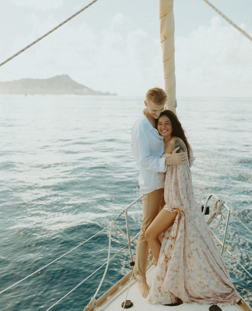 couple hugging in Oahu on the sailboat