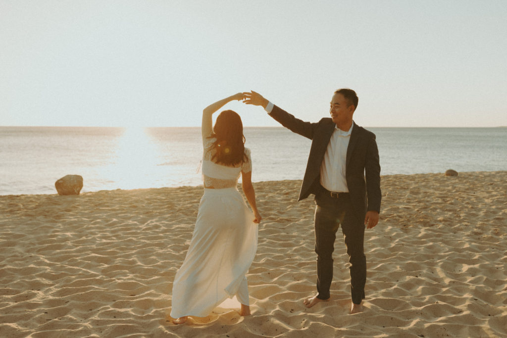bride and groom posing on a beach after for their bridal portraits