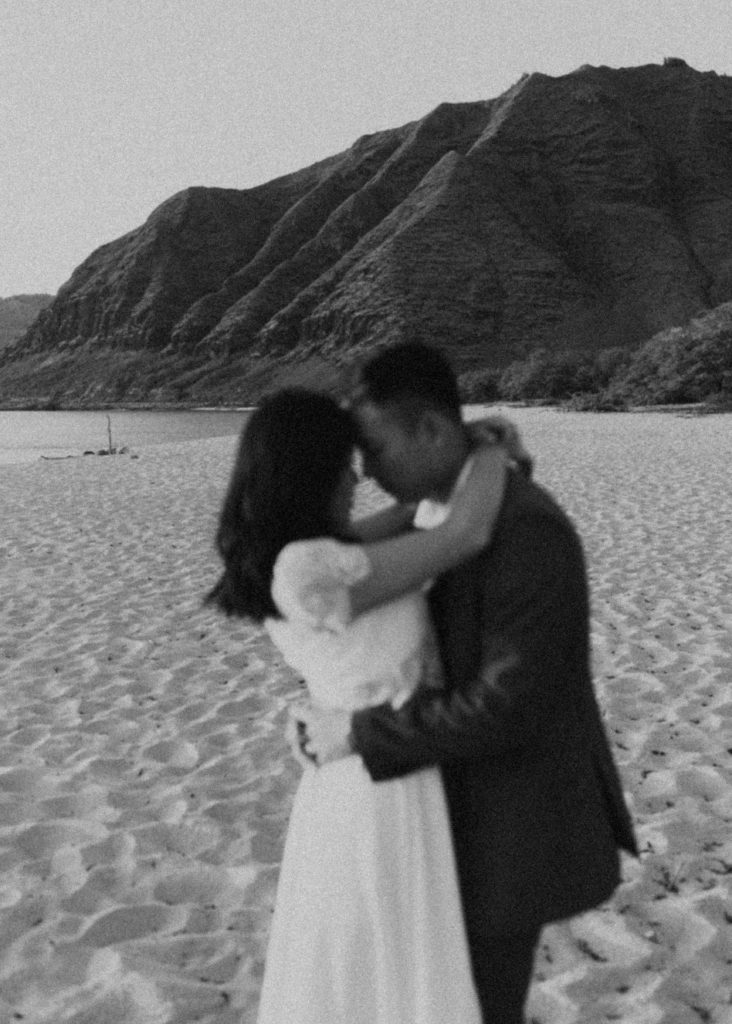 bride and groom posing in hawaii on the beach after their elopement