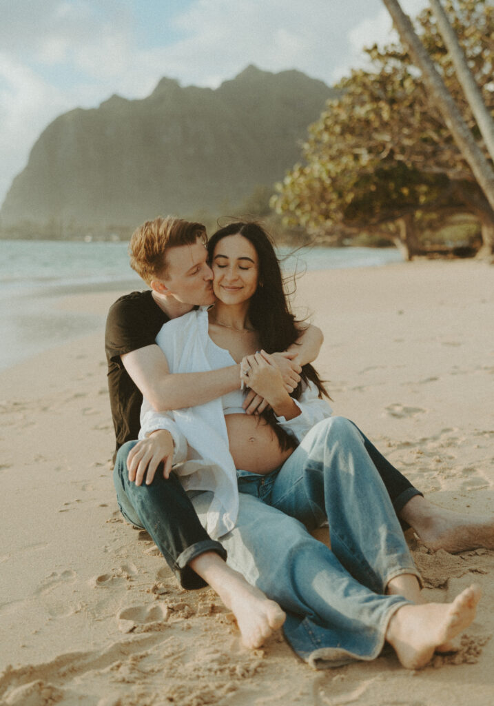 couple posing for their beach maternity photoshoot in Oahu, hawaii