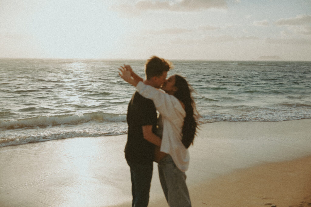 couple posing for their beach maternity photoshoot in Oahu, hawaii