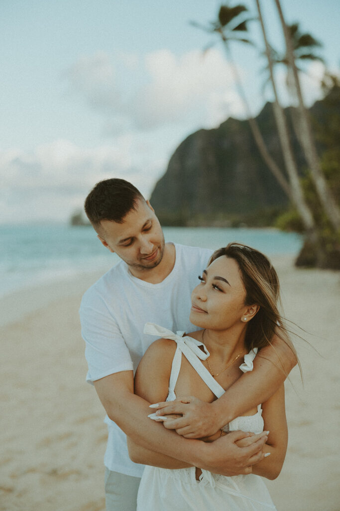 a playful couple posing in hawaii for their engagement photos
