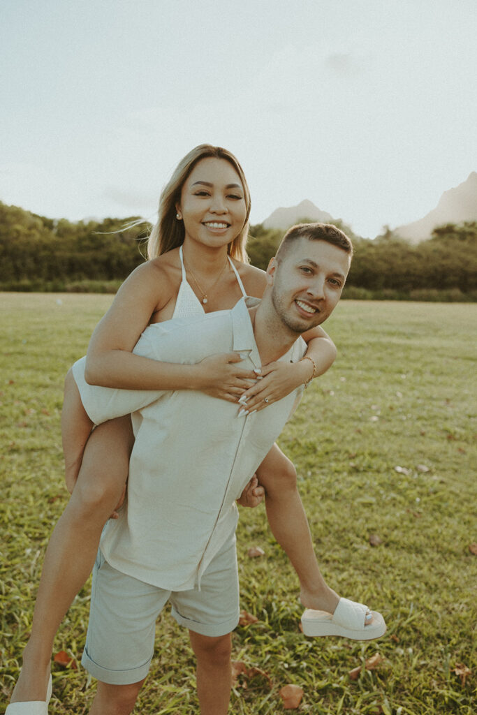 a couple posing for their engagement photos in oahu at kualoa ranch
